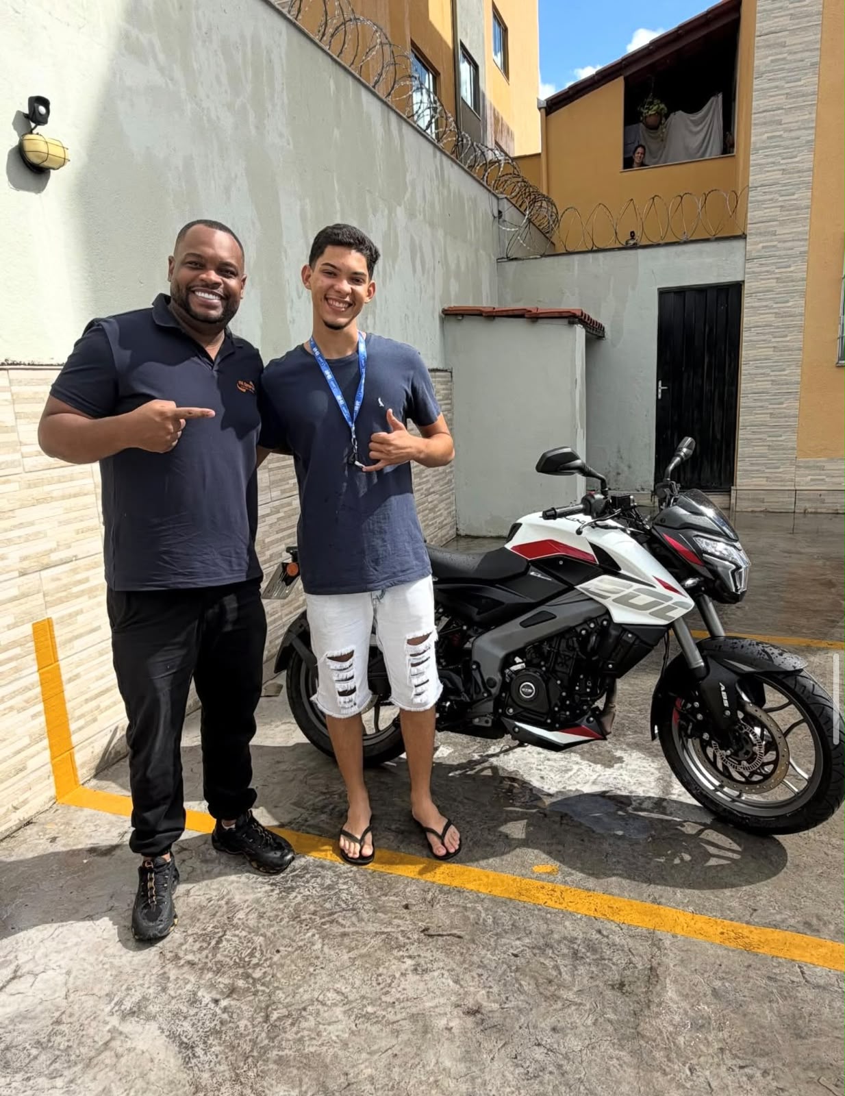 Cliente ao lado da sua moto esportiva com o consultor da FM Consórcios